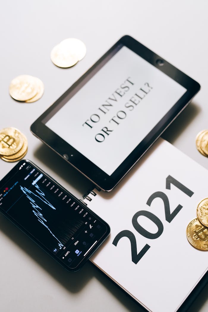 Tablet with investment question amidst bitcoins and 2021 planner. Analyze crypto trends.